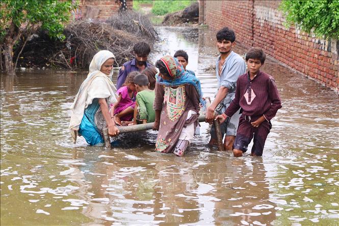 Trong ảnh: Người dân sơ tán khỏi khu vực ngập lụt do mưa lũ tại huyện Tando Allahyar, tỉnh Sindh, miền Nam Pakistan ngày 25/8/2022. Ảnh: THX/TTXVN
