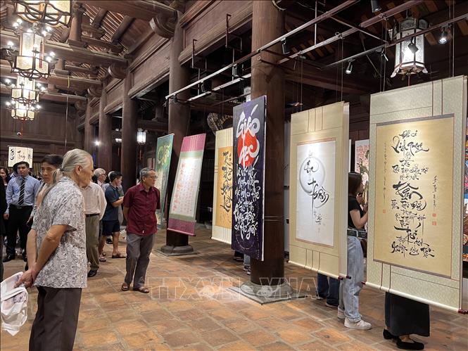 Các đại biểu thưởng lãm các tác phẩm tại Triển lãm “Đối thoại Thư pháp và Graffiti”. Ảnh: Đinh Thuận - TTXVN