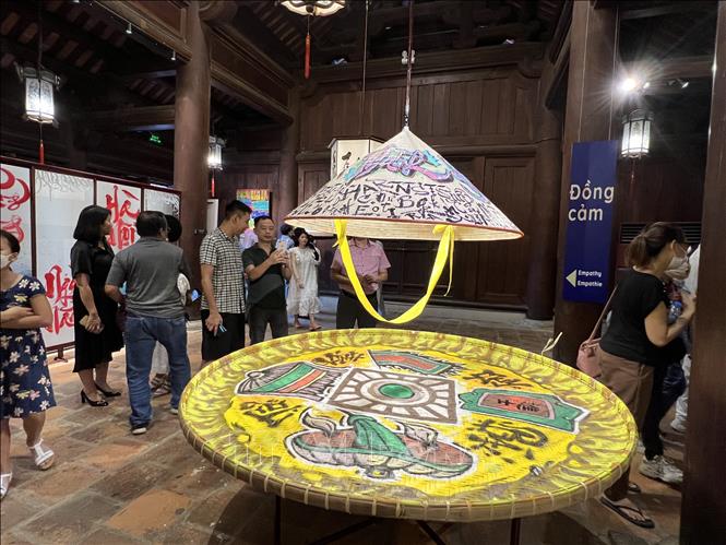 Các đại biểu thưởng lãm các tác phẩm tại Triển lãm “Đối thoại Thư pháp và Graffiti”. Ảnh: Đinh Thuận - TTXVN