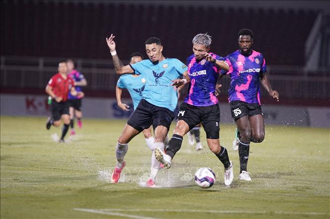 Trong ảnh: Pha tranh bóng giữa cầu thủ đội bóng đá Sài Gòn FC (áo tím) với đội bóng Hồng Lĩnh Hà Tĩnh (áo xanh). Ảnh: Thanh Vũ – TTXVN 
