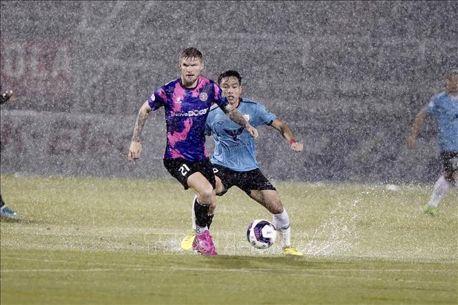 Trong ảnh: Pha tranh bóng giữa cầu thủ đội bóng đá Sài Gòn FC (áo tím) với đội bóng Hồng Lĩnh Hà Tĩnh (áo xanh). Ảnh: Thanh Vũ – TTXVN 

