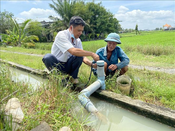 Ông Trần Quốc Thư, Phó Chủ tịch UBND xã Đức Hòa Thượng, huyện Đức Hòa thăm hệ thống kênh dẫn nước vào đồng ruộng. Ảnh: Đức Hạnh - TTXVN