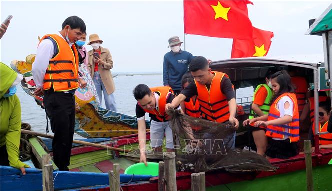 Trong ảnh: Du khách trải nghiệm hoạt động bắt cá trên đầm phá Tam Giang. Ảnh: Tường Vi - TTXVN