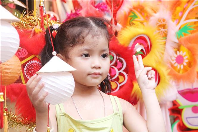 Trong ảnh: Em nhỏ tạo dáng trên Phố lồng đèn. Ảnh: Thu Hương - TTXVN