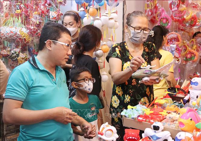 Trong ảnh: Các gia đình đưa con nhỏ tới chọn mua đồ chơi tại Phố lồng đèn. Ảnh: Thu Hương - TTXVN