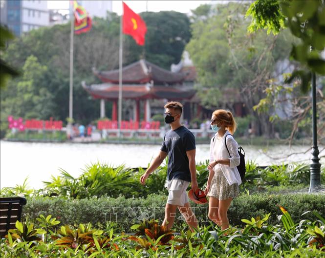 Foreign tourists take a walk around the Hoan Kiem (Sword) Lake in Hanoi. VNA Photo