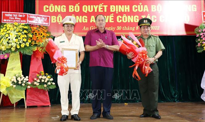 Chủ tịch UBND tỉnh An Giang Nguyễn Thanh Bình tặng hoa chúc mừng Đại tá Đinh Văn Nơi (bìa phải) và Đại tá Lâm Phước Nguyên. Ảnh: Công Mạo-TTXVN