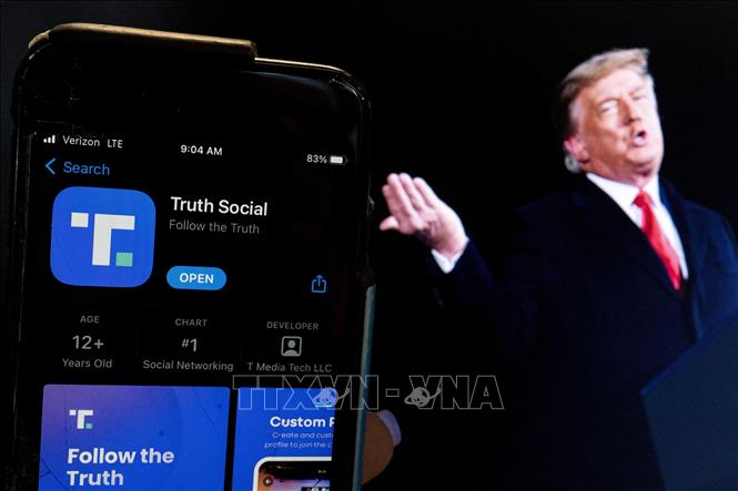Trong ảnh: Biểu tượng mạng xã hội Truth Social trên màn hình điện thoại và hình ảnh cựu Tổng thống Mỹ Donald Trump. Ảnh: AFP/TTXVN