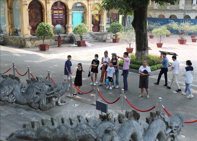 Du khách tham quan, nghe tuyết minh về điện Kính Thiên. Ảnh: Thanh Tùng - TTXVN