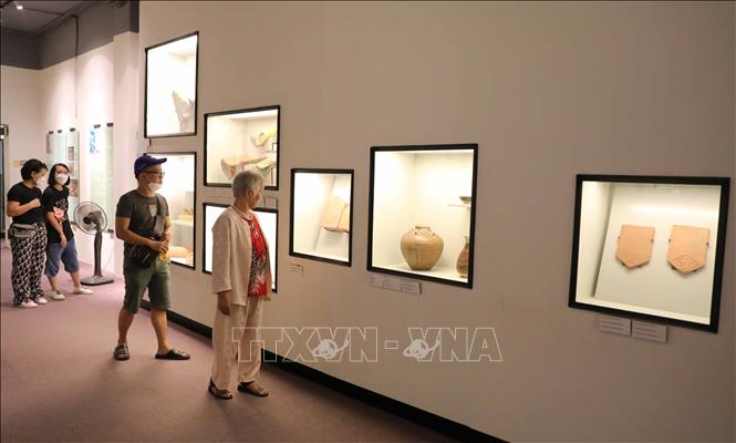 Du khách chiêm ngưỡng các hiện vật được trưng bày tại Hoàng thành Thăng Long. Ảnh: Thanh Tùng - TTXVN