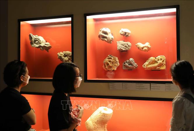 Du khách chiêm ngưỡng các hiện vật được trưng bày tại Hoàng thành Thăng Long. Ảnh: Thanh Tùng - TTXVN