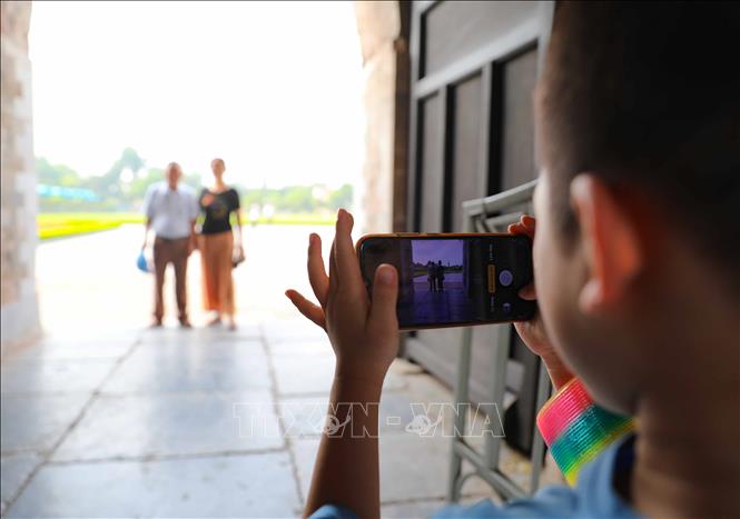 Nhiếp ảnh gia nhí ghi lại hình ảnh lưu niệm cho gia đình khi tham quan Hoàng thành Thăng Long. Ảnh: Thanh Tùng - TTXVN