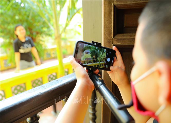 Giúp mẹ lưu lại một tấm hình đẹp khi tham quan ngôi nhà di sản 87 Mã Mây sáng 3/9/2022. Ảnh: Thanh Tùng - TTXVN