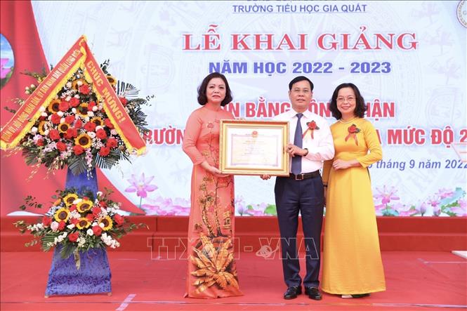 Ông Ngô Mạnh Điềm, Phó bí thư Quận uỷ Long Biên trao Bằng công nhận Trường đạt chuẩn Quốc gia mức độ 2 cho trường Tiểu học Gia Quất. Ảnh: Minh Quyết - TTXVN