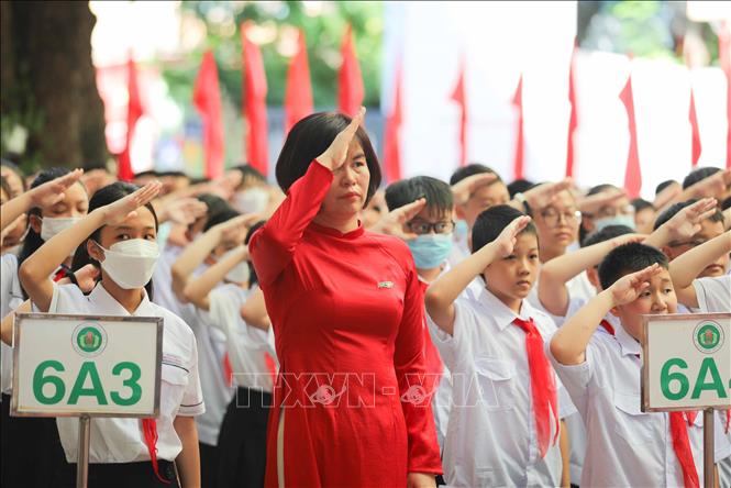Học sinh trường THCS Ngô Sĩ Liên, quận Hoàn Kiếm (Hà Nội) chào cờ trong lễ khai giảng năm học mới 2022 - 2023. Ảnh: Thanh Tùng - TTXVN 