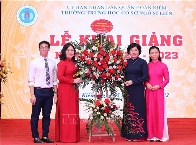 Thứ trưởng Bộ Giáo dục và Đào tạo Ngô Thị Nịnh tặng hoa chúc mừng nhà trường. Ảnh: Thanh Tùng - TTXVN