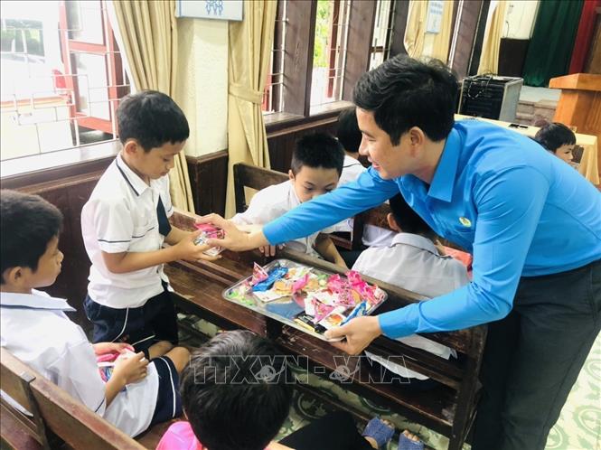 Trong ảnh: Chủ tịch Công đoàn ngành Giáo dục Đặng Văn Hải trao quà cho trẻ em Làng trẻ em SOS Vinh. Ảnh: Bích Huệ - TTXVN