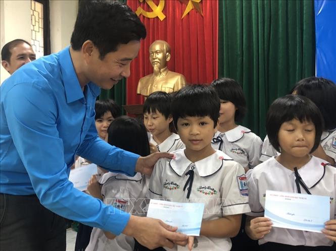 Trong ảnh: Chủ tịch Công đoàn ngành Giáo dục Đặng Văn Hải trao quà cho trẻ em Làng trẻ em SOS Vinh. Ảnh: Bích Huệ - TTXVN
