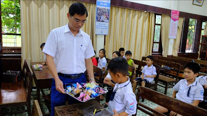 Trong ảnh; Phó Giám đốc Sở Giáo dục và đào tạo Nghệ An Nguyễn Văn Khoa trao quà cho trẻ em Làng trẻ em SOS Vinh. Ảnh: Bích Huệ - TTXVN