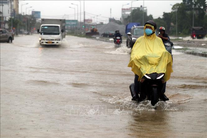 Trong ảnh: Các phương tiện gặp nhiều khó khăn khi di chuyển qua các tuyến đường ngập sâu tại thành phố Vinh (Nghệ An). Ảnh: Tá Chuyên - TTXVN