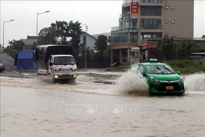 Trong ảnh: Các phương tiện gặp nhiều khó khăn khi di chuyển qua các tuyến đường ngập sâu tại thành phố Vinh (Nghệ An). Ảnh: Tá Chuyên - TTXVN