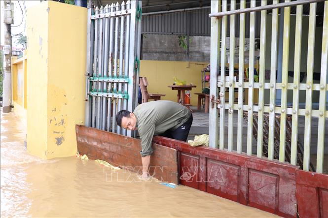 Người dân thôn Ngọc Nhị, xã Gia Thủy, huyện Nho Quan che chắn ngăn nước vào nhà. Ảnh: Đức Phương - TTXVN