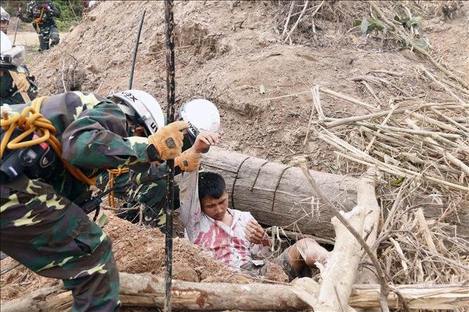 Các chiến sĩ đang đưa một người dân bị cây đè và bị vùi lấp đi cấp cứu trong một tình huống giả định tại diễn tập. Ảnh: Phạm Kiên - Phóng viên TTXVN tại Lào
