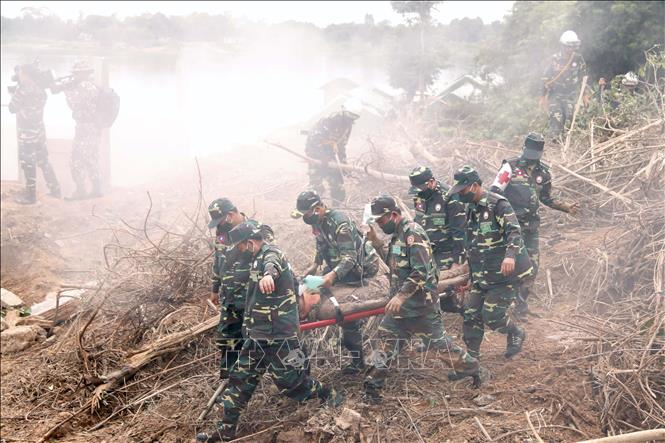 Các chiến sĩ đang đưa một người dân bị bùn, đất bị vùi lấp đi cấp cứu trong một tình huống giả định tại diễn tập. Ảnh: Phạm Kiên - Phóng viên TTXVN tại Lào