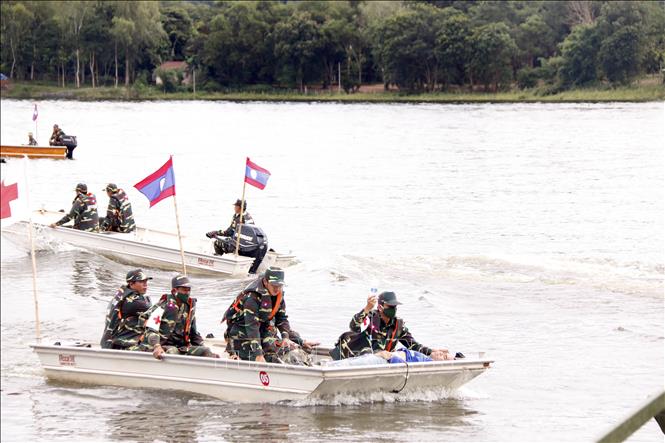 Các thuyền cứu hộ đang đưa một người dân đi cấp cứu trong một tình huống giả định tại diễn tập. Ảnh: Phạm Kiên - Phóng viên TTXVN tại Lào