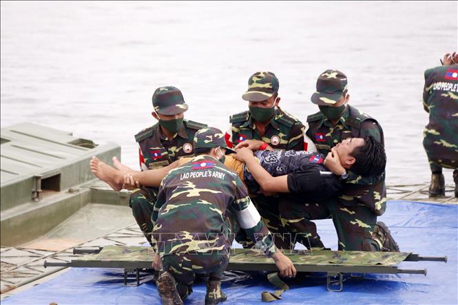 Các chiến sĩ đang đưa một người dân đi cấp cứu trong một tình huống giả định tại diễn tập. Ảnh: Phạm Kiên - Phóng viên TTXVN tại Lào