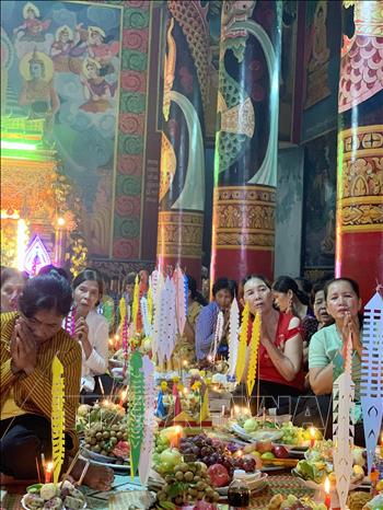 Đồng bào Phật tử tề tựu nghe sư tụng kinh cầu phúc của sư sãi rồi mới tiến hành lễ đặt cơm nếp vắt. Ảnh: Chanh Đa-TTXVN
