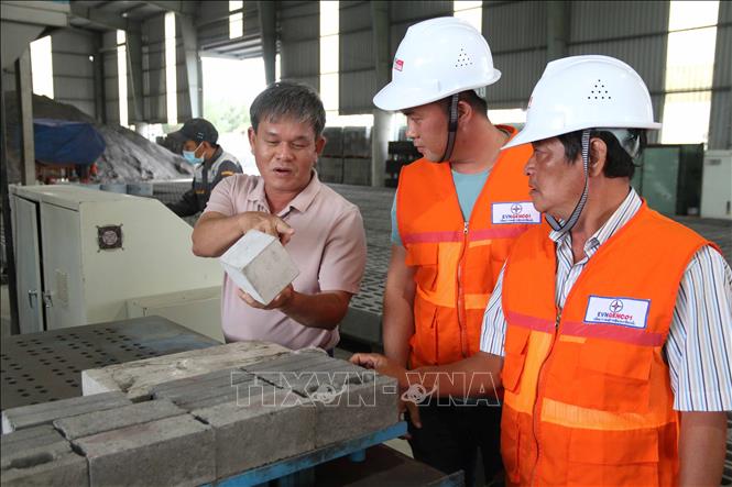 Trong ảnh: Ông Nguyễn Quang Huân, Giám đốc Công ty Trách nhiệm hữu hạn Vật liệu xanh Duyên Hải DGM giới thiệu gạch không nung sản xuất tại nhà máy. Ảnh: Thanh Hòa - TTXVN
