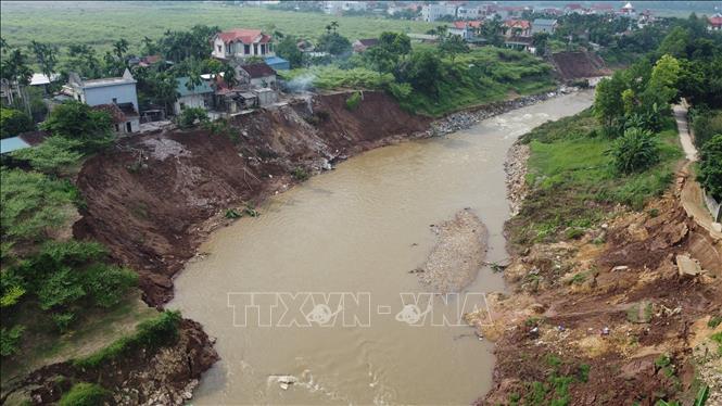 Mưa lũ làm hàng trăm mét đất bị sạt xuống sông, uy hiếp nhiều ngôi nhà của người dân tại xã Lương Nha, huyện Thanh Sơn. Ảnh: Tạ Toàn – TTXVN