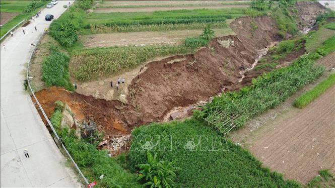 Cống tiêu Ngòi Tre, đoạn Tỉnh lộ 317A bị sạt lở ăn sâu vào lòng đường với chiều dài khoảng 50m, toàn bộ phần tôn hộ lan và các trụ bị đổ gãy, đồng thời ăn sâu vào phía chân đường. Ảnh: Tạ Toàn – TTXVN