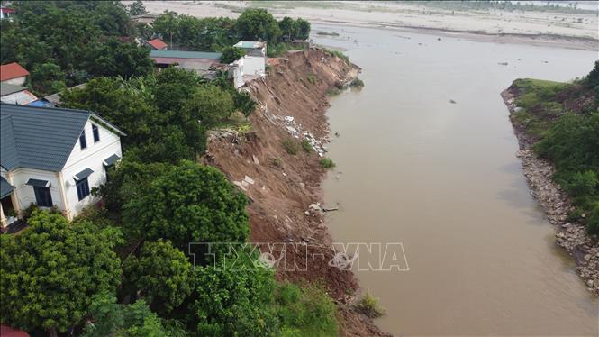 Sạt lở nghiêm trọng tại ngòi Lạt qua xã Tu Vũ, làm hai ngôi nhà của người dân khu 2, xã Tu Vũ bị lở xuống ngòi Lạt. Ảnh: Tạ Toàn – TTXVN