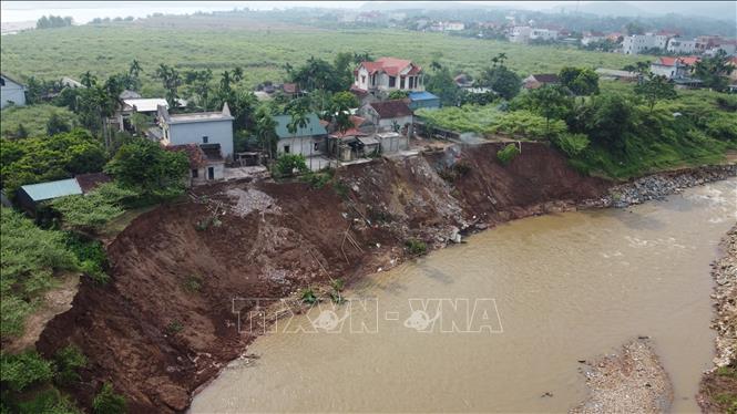 Sạt lở nghiêm trọng tại ngòi Lạt qua xã Tu Vũ, làm hai ngôi nhà của người dân khu 2, xã Tu Vũ bị lở xuống ngòi Lạt. Ảnh: Tạ Toàn – TTXVN