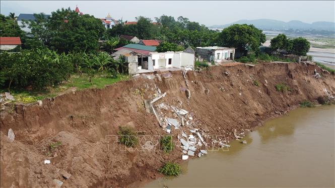 Sạt lở nghiêm trọng tại ngòi Lạt, xã Tu Vũ, làm nhiều ngôi nhà bị trôi xuống ngòi, uy hiếp hàng chục hộ dân trong xã. Ảnh: Tạ Toàn – TTXVN