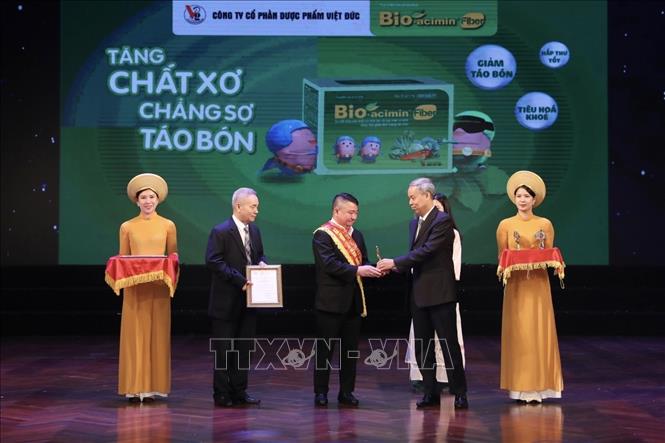 Ban tổ chức trao huy chương Vàng và giấy chứng nhận cho 25 doanh nghiệp đạt giải. Ảnh: Minh Quyết - TTXVN