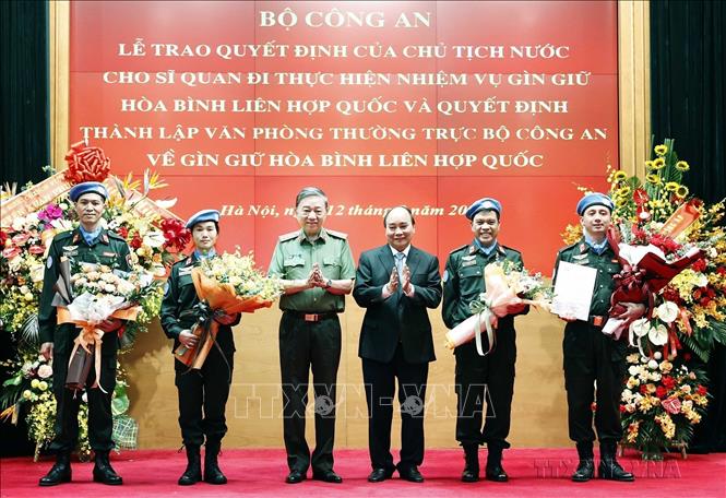 Chủ tịch nước Nguyễn Xuân Phúc trao Quyết định cho sĩ quan công an đi thực hiện nhiệm vụ gìn giữ hoà bình LHQ và Quyết định thành lập văn phòng thường trực Bộ Công an về gìn giữ hoà bình LHQ (Hà Nội, 12/8/2022). Ảnh: Thống Nhất – TTXVN