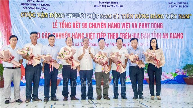 Trong ảnh: Lãnh đạo Uỷ ban Mặt trận Tổ quốc Việt Nam tỉnh An Giang tặng hoa chúc mừng các đơn vị góp công lớn đưa hàng Việt về nông thôn An Giang. Ảnh: Thanh Sang - TTXVN