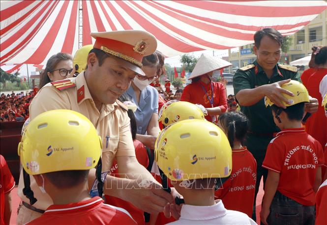 Trong ảnh: Tặng mũ bảo hiểm cho các học sinh trường Tiểu học Hương Sơn tại chương trình. Ảnh: Hoàng Hùng -TTXVN