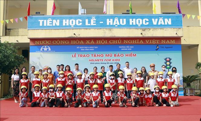 Trong ảnh: Học sinh trường Tiểu học Hương Sơn được tặng mũ bảo hiểm tại chương trình. Ảnh: Hoàng Hùng -TTXVN
