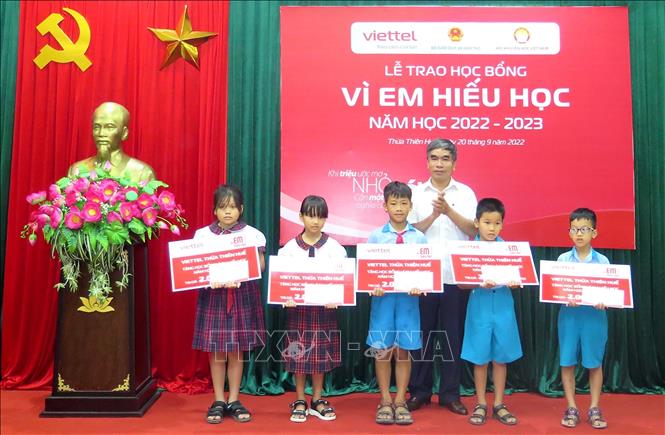 Trong ảnh: Trao học bổng cho các em học sinh. Ảnh: Tường Vi - TTXVN. 