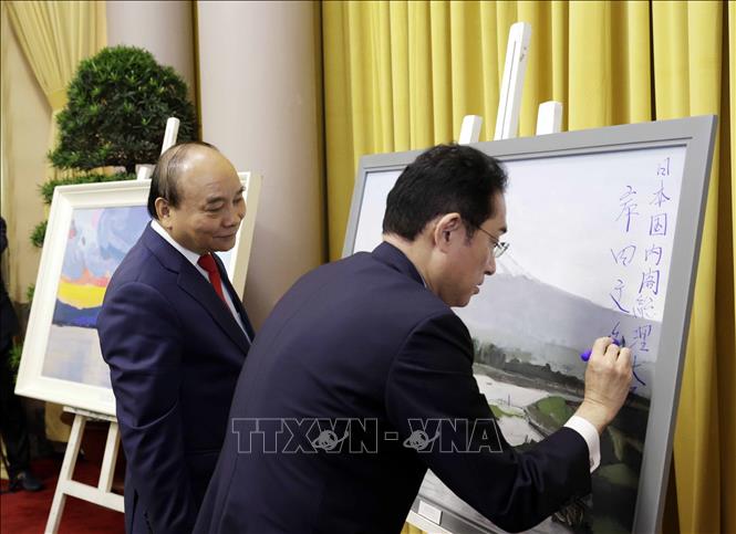 Thủ tướng Nhật Bản Kishida Fumio ký tặng Chủ tịch nước Nguyễn Xuân Phúc tác phẩm hội họa của hoạ sỹ Việt Nam về phong cảnh Nhật Bản trong chuyến thăm chính thức Việt Nam (1/5/2022). Ảnh: Thống Nhất – TTXVN
