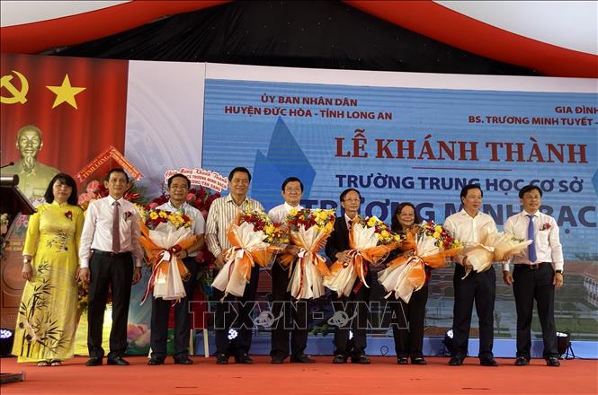 Lãnh đạo huyện Đức Hòa tặng hoa cảm ơn nhà tại trợ và lãnh đạo các cấp vì đã đóng góp đầu tư cho giáo dục địa phương. Ảnh: Đức Hạnh - TTXVN 