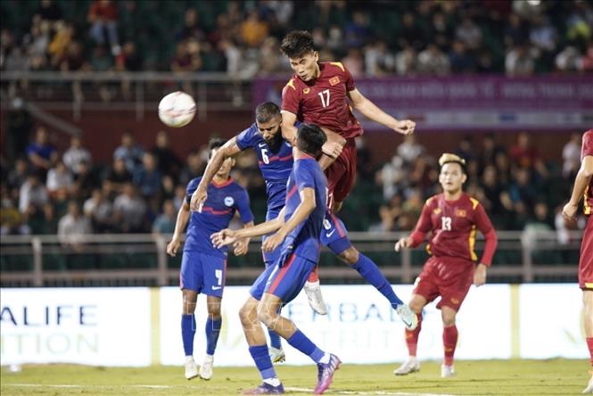 Vietnamese (red shirts) and Singaporean (blue shirts) football players fight in mid-air for the ball. VNA Photo: Thanh Vũ