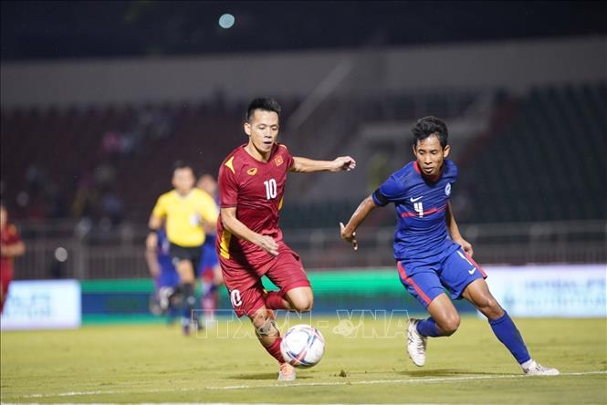 Vietnamese (red shirts) and Singaporean (blue shirts) football players fight for the ball in the match. VNA Photo: Thanh Vũ