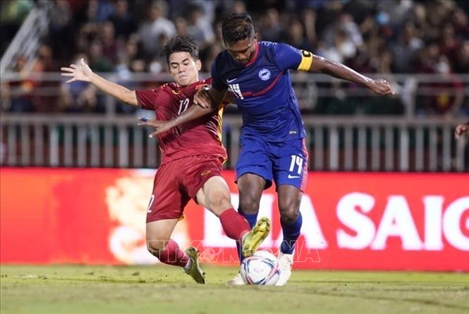 Vietnamese (red shirt) and Singaporean (blue shirt) football players fight for the ball in the match. VNA Photo: Thanh Vũ