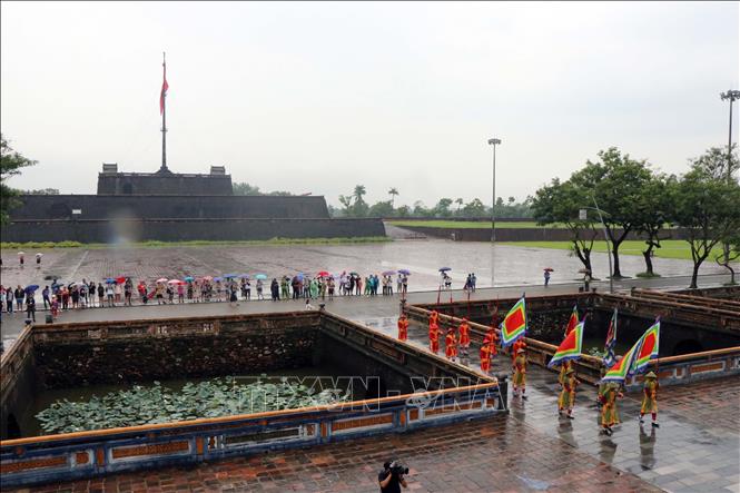 Foreign tourists watch a guard changing ceremony restaged at the Hue Imperial Citadel. VNA Photo: Đỗ Trưởng