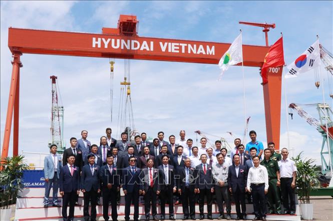 Trong ảnh: Các đại biểu chụp ảnh lưu niệm bên cẩu trục Goliath 700 tấn. Ảnh: Tiên Minh – TTXVN